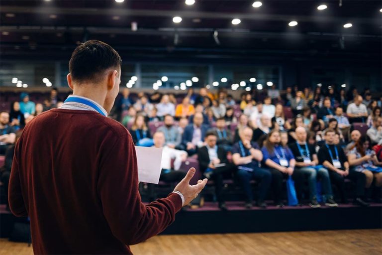 Event-Insurance-Business-Conference-with-a-Man-on-Stage-Talking-About-Performance
